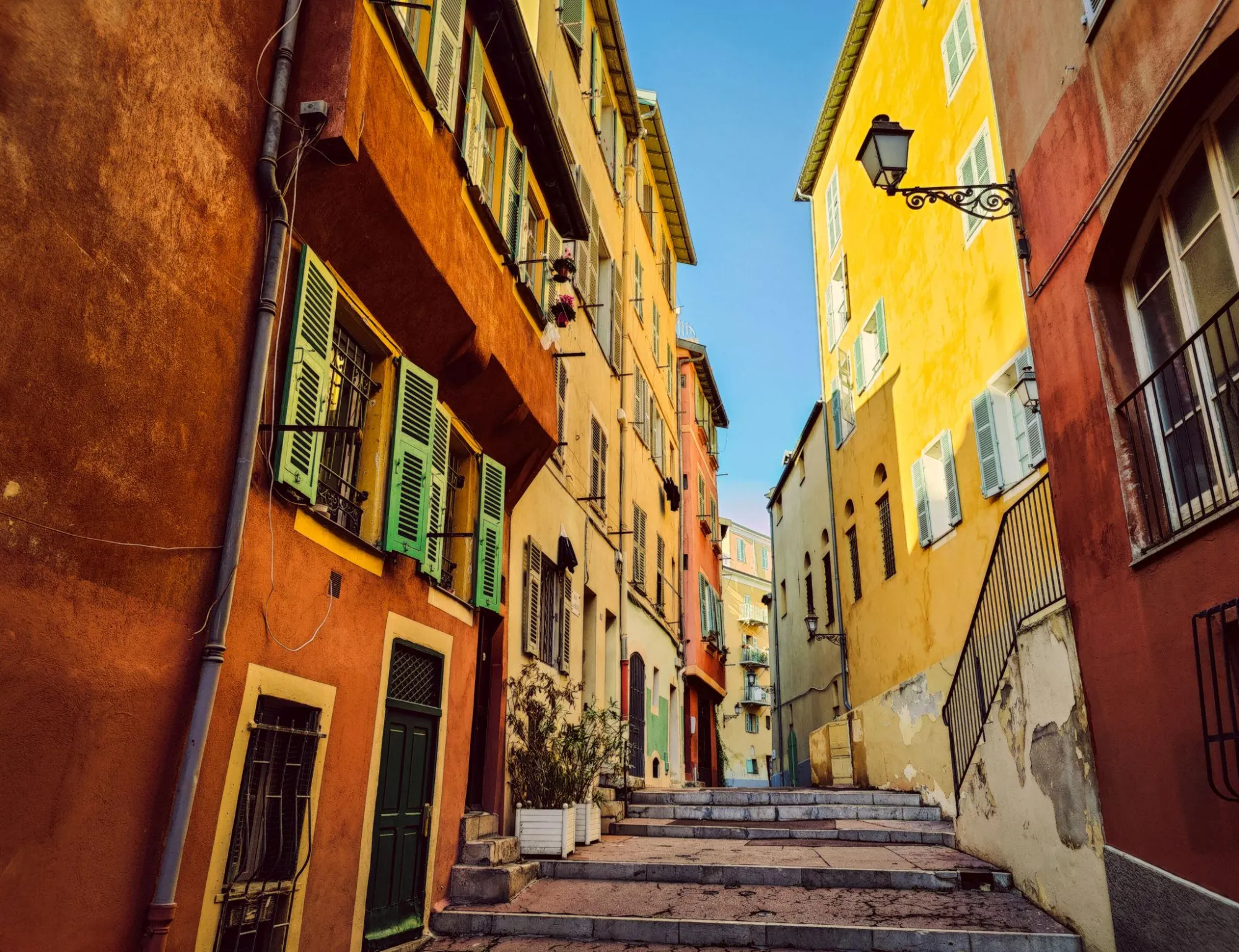 Ruelle colorée du Vieux-Nice avec façades ocre et jaunes