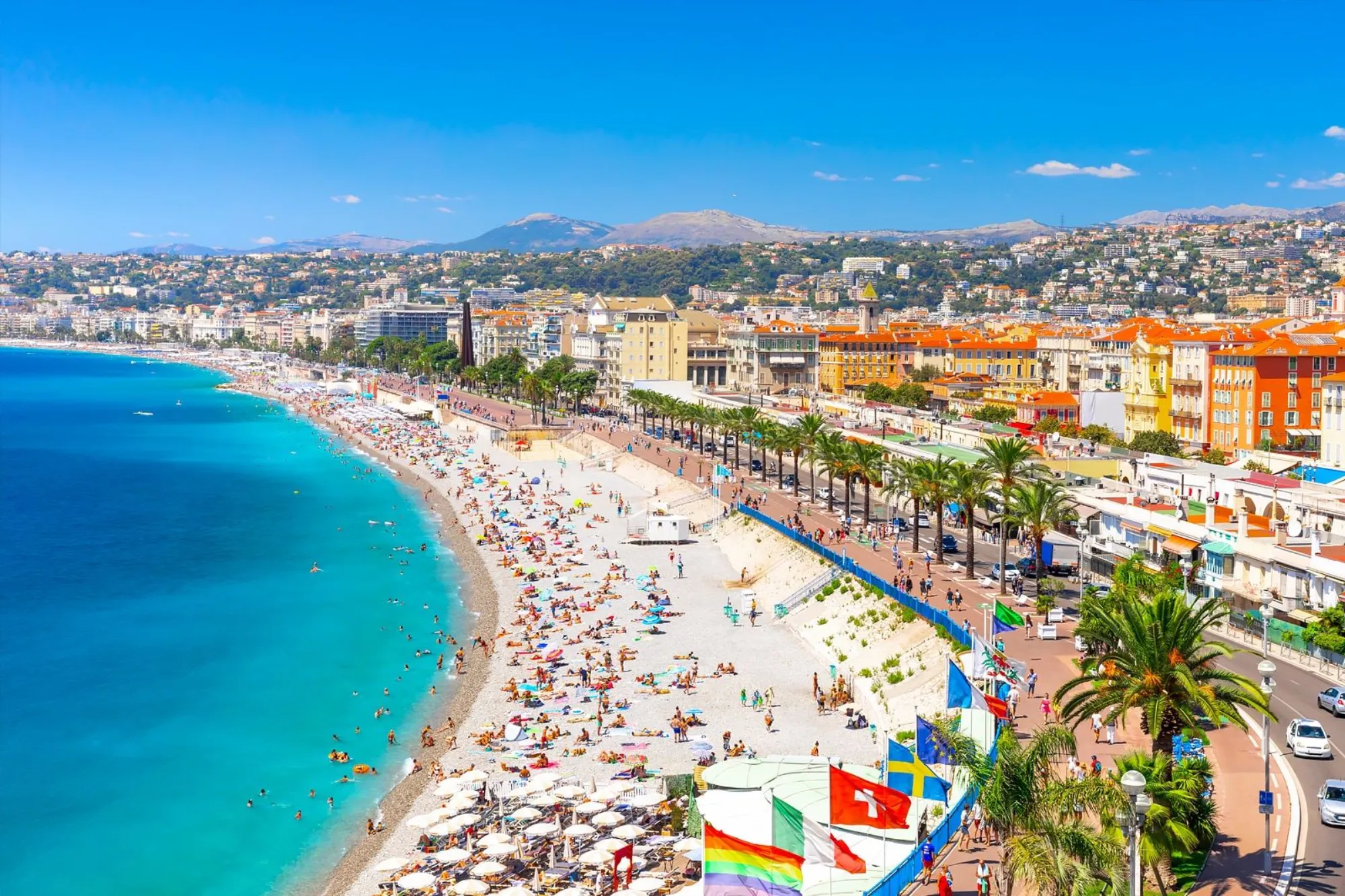 Plage de Nice avec parasols et promenade des Anglais