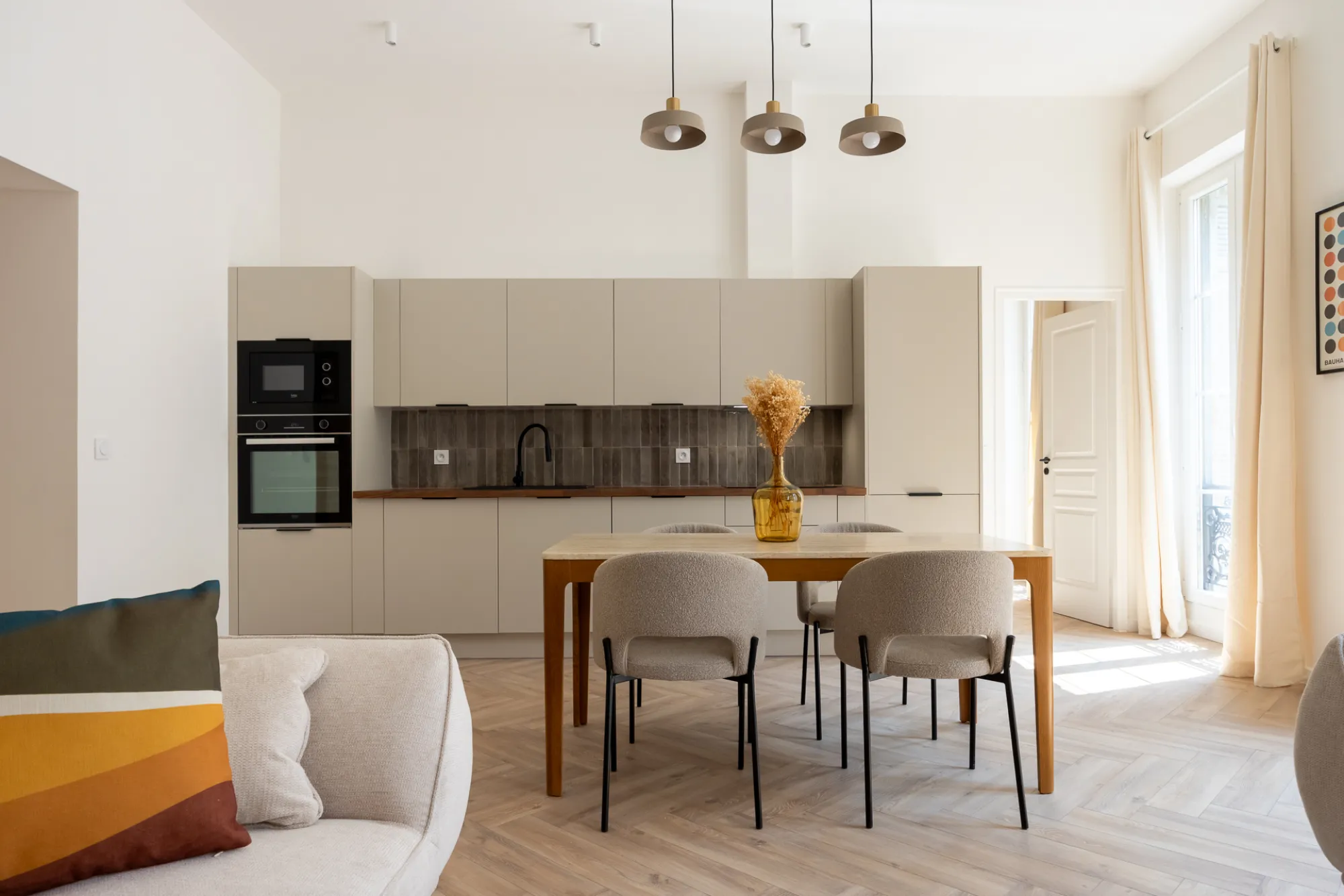 Cuisine moderne rénovée avec pendentifs et table en bois