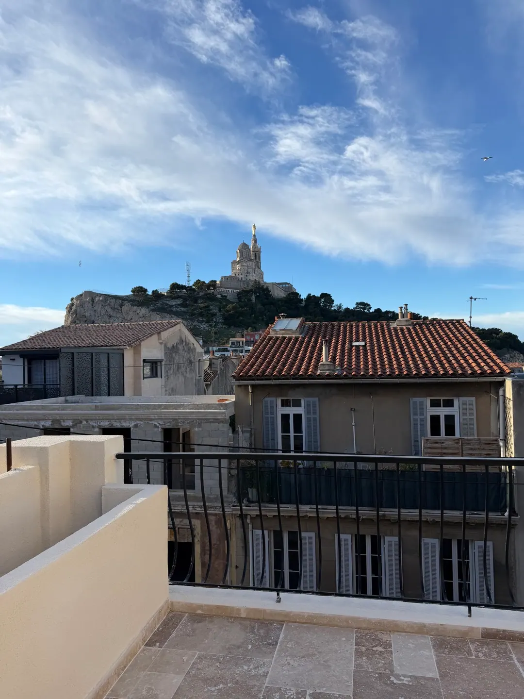 Vue sur Notre-Dame de la Garde depuis la terrasse d'un bien rénové à Marseille